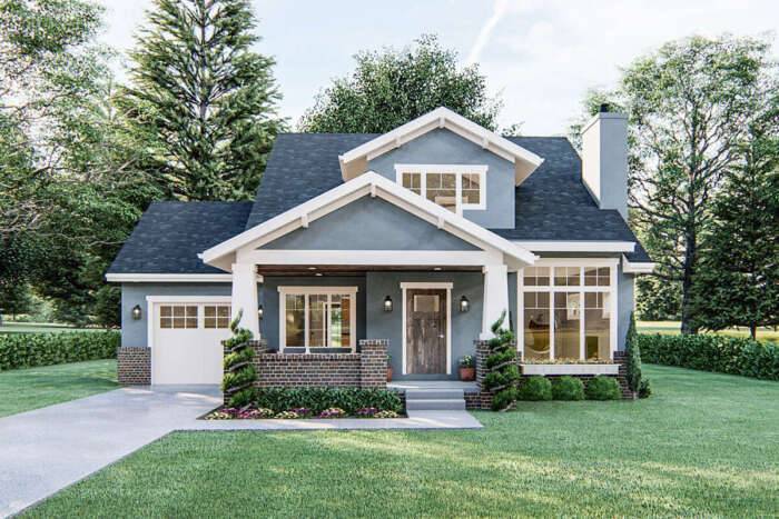 Adorable blue bungalow cottage home with attached garage and landscaped green lawn